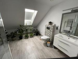 a bathroom with a sink and a toilet and plants at Farma IT in Jamielnik