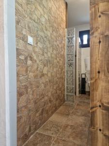 a room with a stone wall and a hallway at EL NIDO dEL AGUILA HOTEL LAS GACELAS in Becerril de la Sierra