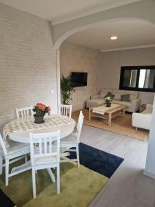 ein Wohnzimmer mit einem weißen Tisch und Stühlen in der Unterkunft EL NIDO dEL AGUILA HOTEL LAS GACELAS in Becerril de la Sierra