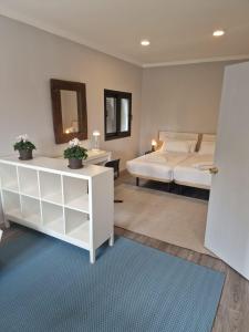 um quarto com uma cama e uma cómoda branca em EL NIDO dEL AGUILA HOTEL LAS GACELAS em Becerril de la Sierra