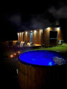 a hot tub in front of a cabin at night at Domek nad stawem in Swiętajno