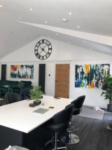 a meeting room with a table and a clock on the wall at Modern 2 bedroom town centre apartment in Tamworth in Tamworth