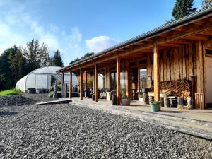 une maison avec une serre en arrière-plan dans l'établissement Móðir Jörð Organic Farm Guesthouse in Vallanes, à Vallanes