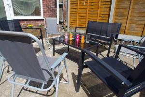 a table and chairs sitting on a patio at Vibrant 4 Bedroom House With Game Area & Garden in Southampton