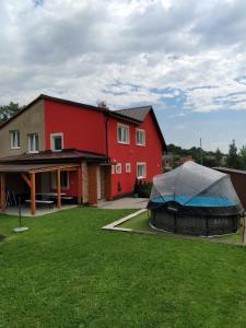 a red house with a tent in front of it at Chalupa Maršovice in Nové Město na Moravě