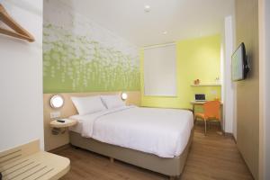 Rúm í herbergi á Zest Jemursari by Swiss-Belhotel International
