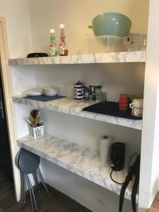 a kitchen with marble shelves with dishes on them at Coquet Studio PROCHE CENTRE in Strasbourg