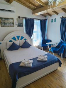 a bedroom with a bed with blue chairs and a table at MAVİ PALAS HOTEL in Buyukada +72 photos
