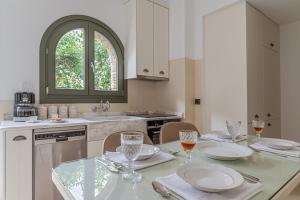 eine Küche mit einem Tisch mit Tellern und Gläsern darauf in der Unterkunft Mrs Kalis cottage in Ándros
