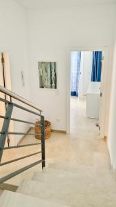 een witte kamer met een trap en een schilderij aan de muur bij Amazing cozy Villa Hugo Tauro with Jacuzzi, Pool, Wi-Fi in Mogán