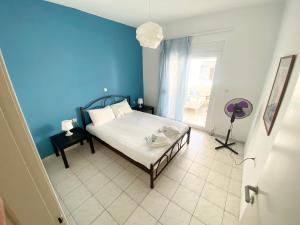 a bedroom with a bed and a blue wall at Korona Beach Apartments I in Rethymno