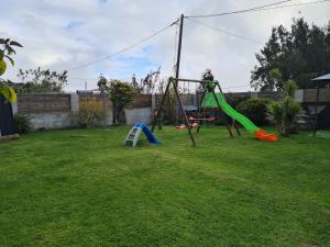 a yard with a playground with a swing set at La Kaz Miel vert in Le Tampon