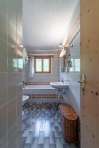 La salle de bains est pourvue d'une baignoire, d'un lavabo et de toilettes. dans l'établissement Chesa Gravulaina - Madulain, à Madulain