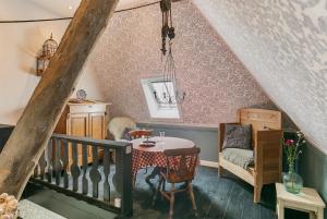 a attic room with a table and a chair at Inn Friesland in Ternaard