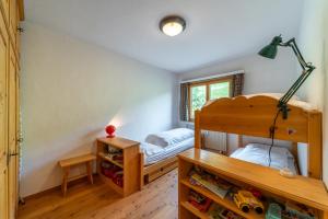 a bedroom with a bunk bed and a desk with a table at Chesa Gravulaina - Madulain in Madulain