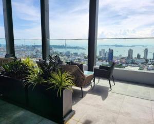 a room with chairs and a view of a city at Once Pattaya Seaview Condo in Pattaya Central