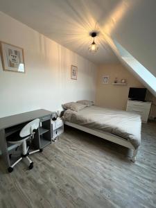 a bedroom with a bed and a desk with a desk at Chambre chez thomas in Glos-sur-Lisieux