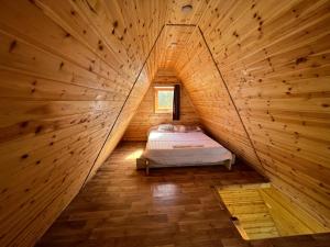 ジャラシュにあるNature Forest Cabinsの木造キャビン内のベッド1台が備わる小さな客室です。
