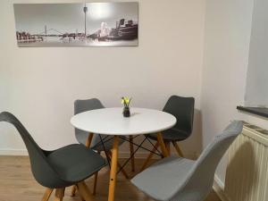 uma mesa e cadeiras com uma mesa branca e um vaso sobre ela em Wohnung mit Balkon am Rhein em Dusseldorf