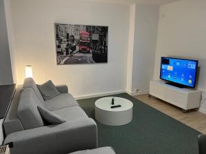 uma sala de estar com um sofá e uma televisão em Wohnung mit Balkon am Rhein em Dusseldorf