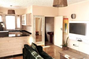 a living room with a couch and a kitchen at Stunning 3-Bed House in Harare in Harare