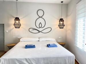 sypialnia z łóżkiem z dwoma niebieskimi ręcznikami w obiekcie Casa Lujosa con Sauna y Jacuzzi en la montaña. w mieście Tavernes de Valldigna