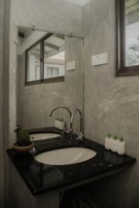 ein Bad mit einem Waschbecken und einem Spiegel in der Unterkunft Sea Crest Beach Villa in Ambalangoda