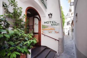 a hotel entrance with stairs and a sign on a building at Amalfi Suite Boutique Hotel in Amalfi