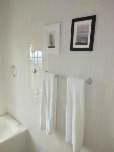a bathroom with white towels hanging on a wall at harmonious two bed cottage with breathtaking views in Kajiado
