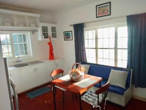 a kitchen with a table and a blue couch at harmonious two bed cottage with breathtaking views in Kajiado
