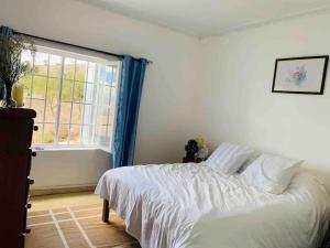 a bedroom with a white bed and a window at harmonious two bed cottage with breathtaking views in Kajiado