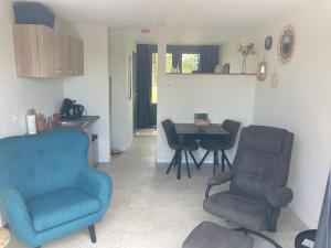 ein Wohnzimmer mit einem blauen Stuhl und einem Tisch in der Unterkunft Het oude strandhuis in Uitgeest