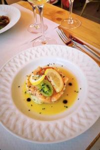 a white plate with a piece of food on a table at La Maison à Pan De Bois Chambre Napoléon III in Vierzon