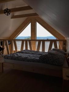 a bed in a room with a large window at Domki Na Wiosce in Stryszowa