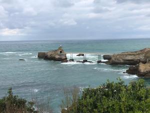 eine kleine Insel im Ozean mit einem Leuchtturm in der Unterkunft Villa Bella à 250m des plages in Biarritz