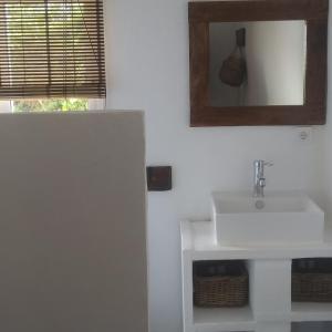 uma casa de banho com um lavatório branco e um espelho. em Casa rural la luz de Ari em Traspinedo