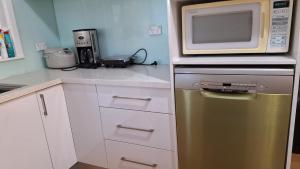 a kitchen with a microwave on top of a refrigerator at A cozy place in Noble Park