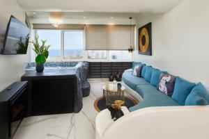 sala de estar con sofá azul y TV en Artion Luxe Apartment, en Vourvoúlos