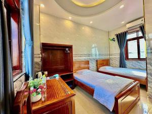 Un dormitorio con 2 camas y una mesa con flores. en Khách sạn Vĩnh Chương, en Soc Trang