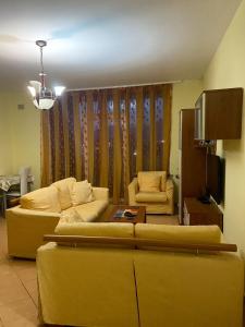 sala de estar con 2 sofás y TV en YourHome Vilat Gjermane, en Tirana