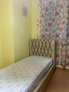 Cama pequeña en habitación con cortina en YourHome Vilat Gjermane, en Tirana