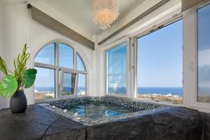 Vourvoúlos的住宿－Artion Luxe Apartment，带大窗户的客房内的按摩浴缸