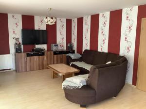 a living room with a couch and a tv at Ferienhaus Juleta in Briesen