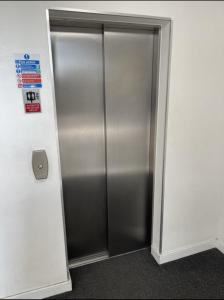 a stainless steel elevator in an office building at Amazing Luxury Double Bedroom with en-suite shower and free parking with a Sound bar & smart TV in a two bed Apartment I live in the 2nd room in Belvedere