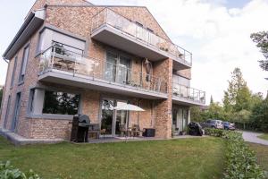 ein Backsteinhaus mit einem Balkon und einer Terrasse in der Unterkunft Familiensuite BoHo am See - Netflix - Grill - Parken in Möhnesee