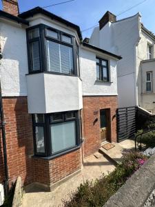 une maison en briques avec des fenêtres noires et blanches dans l'établissement Stylish Unique 3 Bedroom House Hastings, à Hastings