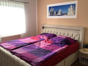 a bed with a purple comforter in a bedroom at Ferienhaus Juleta in Briesen