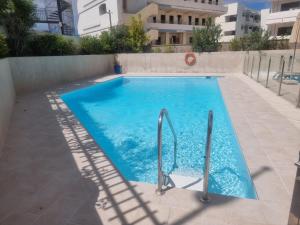 a swimming pool with blue water in a building at Apartamento en Playa del Inglés Los Mangos in Playa del Ingles