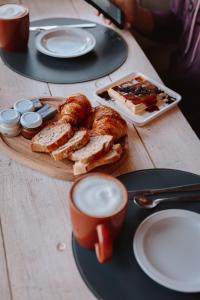 a table with a plate of bread and cups of coffee at Peninsula Petit in San Carlos de Bariloche