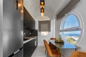 a kitchen with a table and an arch window at Artion Luxe Apartment in Vourvoúlos